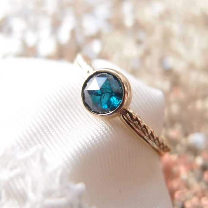 Dainty engagement ring with blue diamond